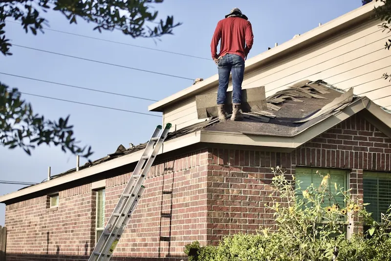 Professional roofer working on a residential roof in Country Lake